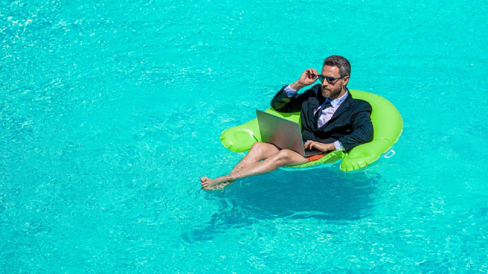 Мужчина в пиджаке в бассейне с ноутбуком 